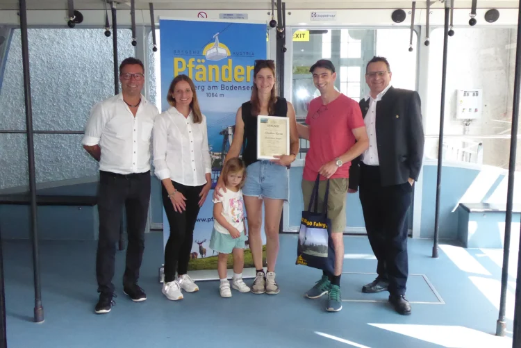 Pfänderbahn Vorstand DI Thomas Kinz, Betriebsleiter Berthold Martan und Corinna Seiter gratulieren Claudiane Vuarnoz. Auf dem Foto ist auch die Familie von Claudiane zu sehen.