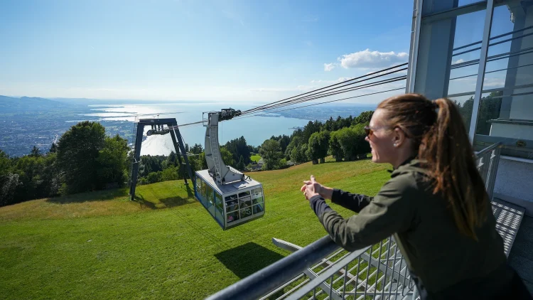 Frau geniesst den Ausblick vom Pfänder über Bregenz und den Bodensee