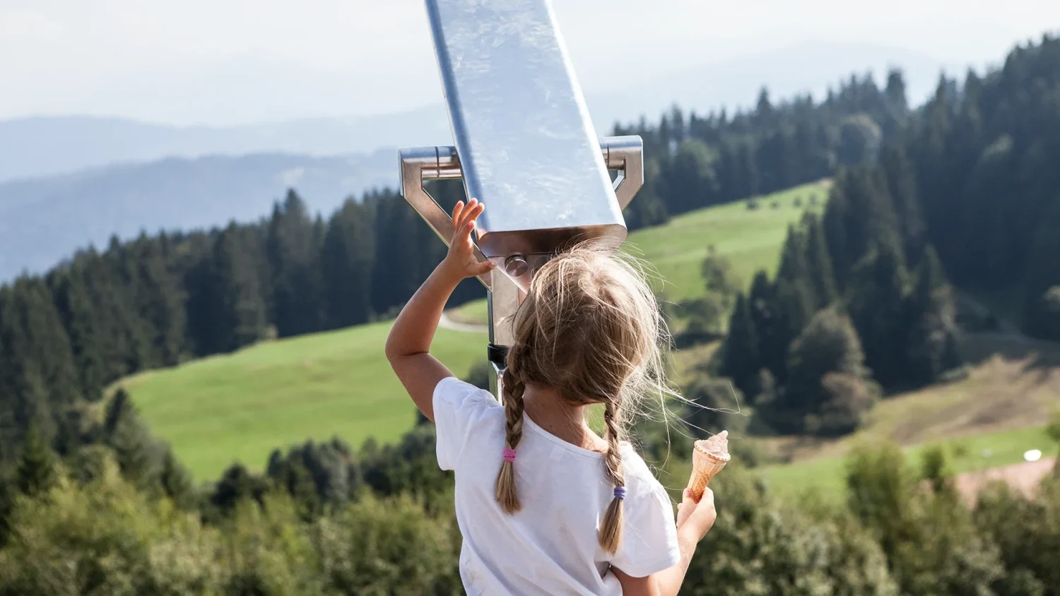 Mädchen schaut durch das Fernglas am Pfänder