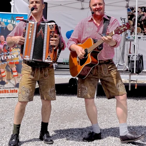 Zwei Musiker in Tracht spielen Akkordeon und Gitarre.