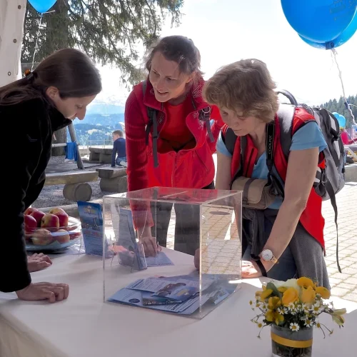 Drei Frauen diskutieren an einem Informationsstand.