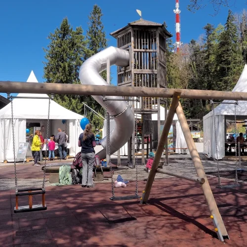 Spielplatz mit Rutsche und Schaukel bei Festzelt