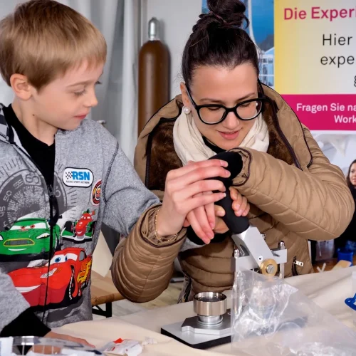 Kind und Frau forschen gemeinsam an einem Experiment.