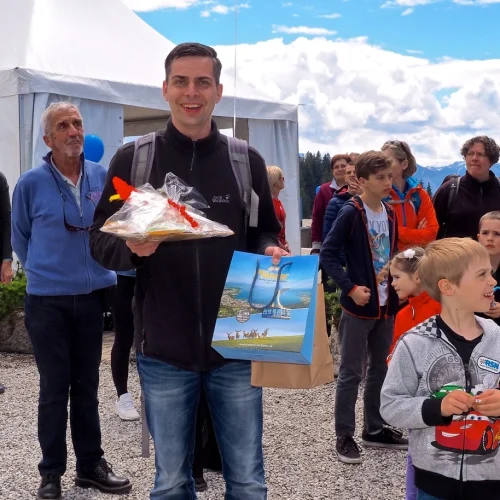 Mann bei Veranstaltung mit Preisen vor Zelt.