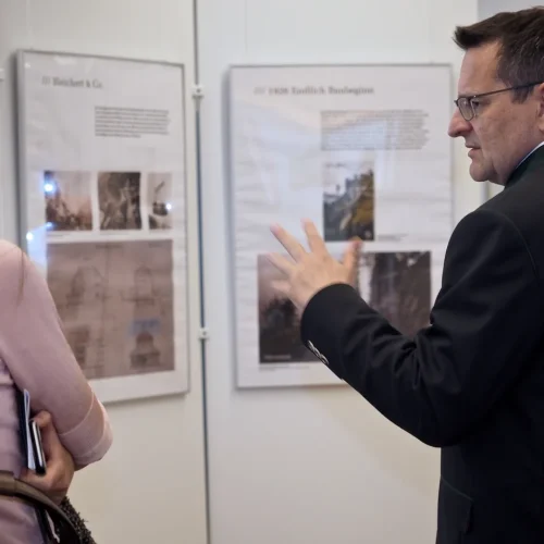 Zwei Personen diskutieren vor Ausstellungstafeln im Museum.