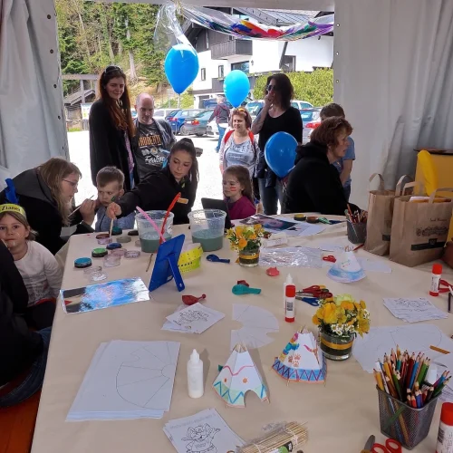 Kinder basteln bei einer Familienveranstaltung im Zelt.