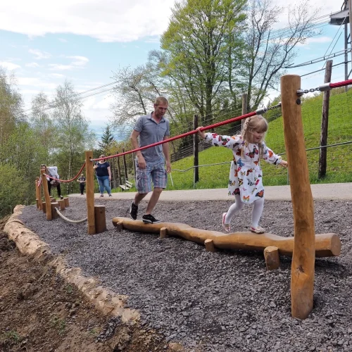 Kind balanciert auf Holzbalken im Freien