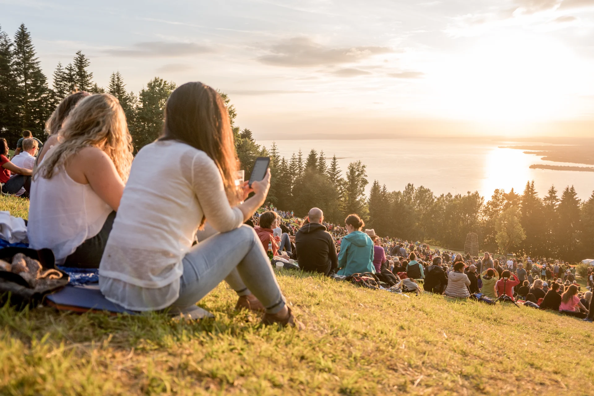 Personen sitzen am Pfänderhang beim Sonnwendfest